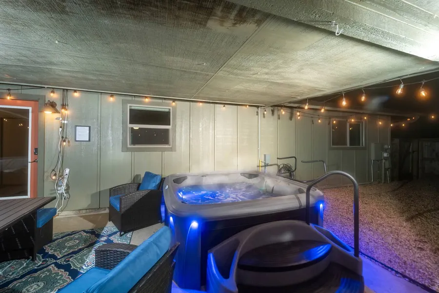 Covered hot tub lounge lit up at night at UptownBnB