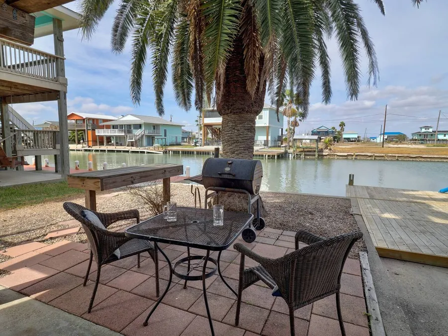 Waterfront patio dining under a palm on the Rockport canal